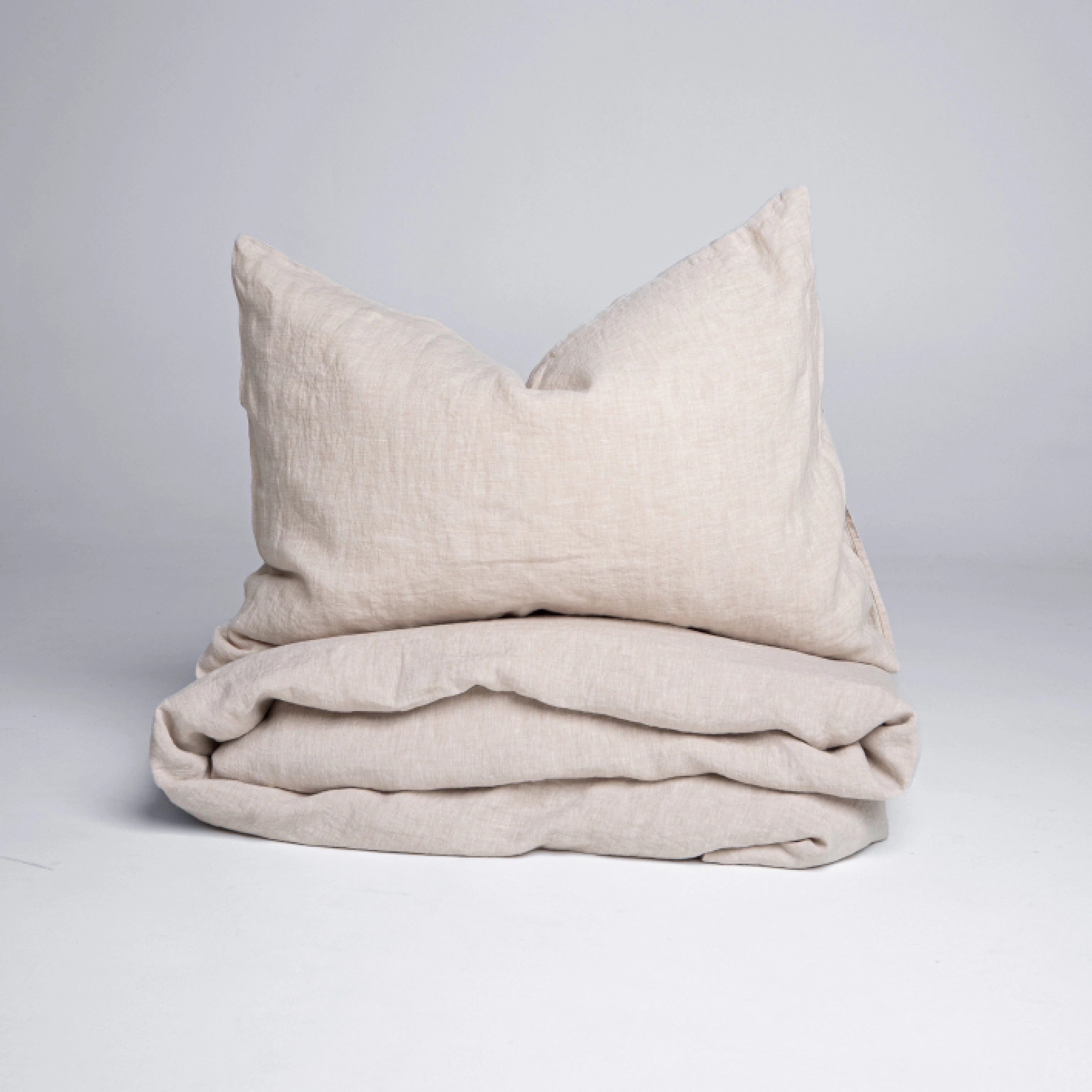 Soft beige natural linen bedding including duvet cover and pillowcases.