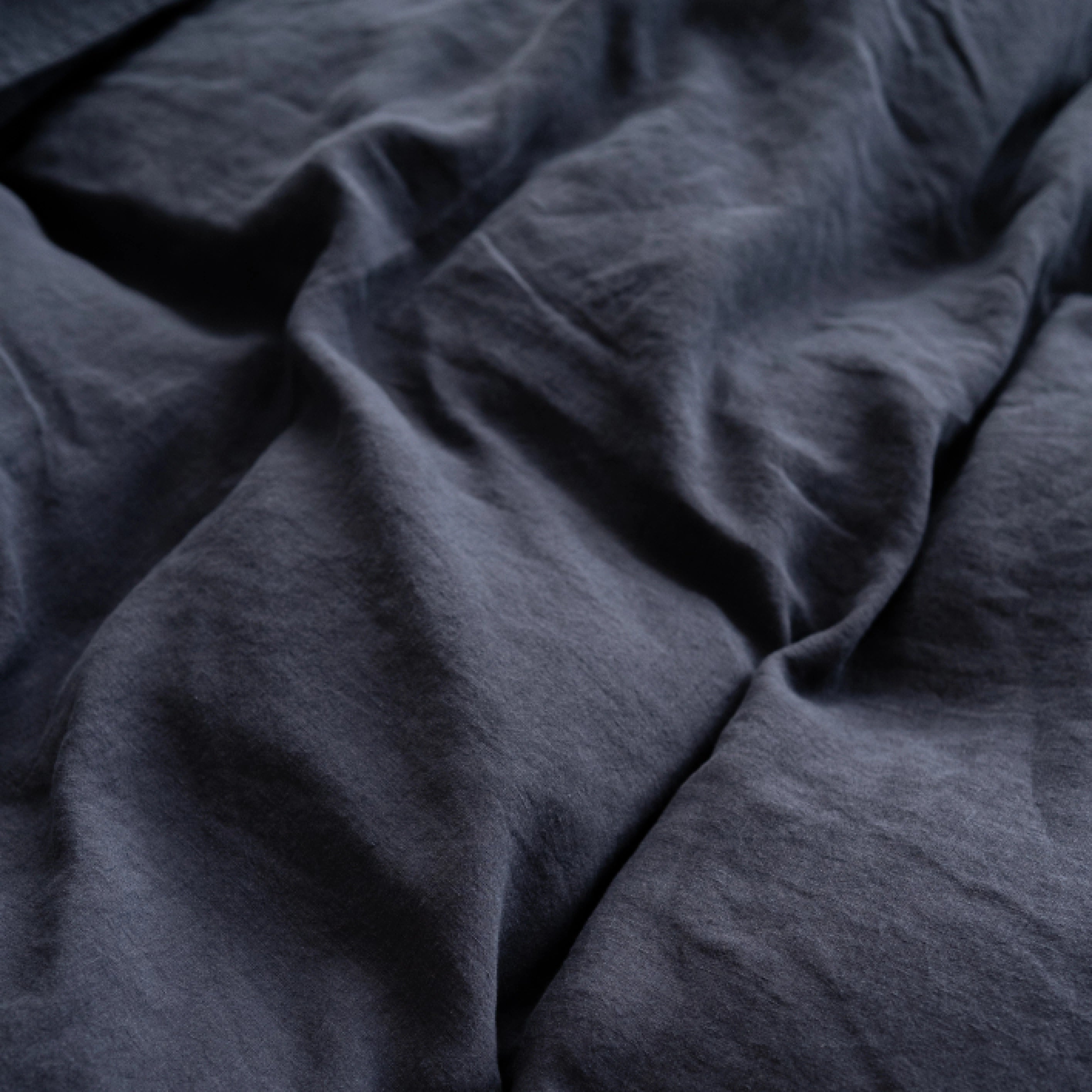 Close-up texture of dark grey stonewashed European flax linen fabric.