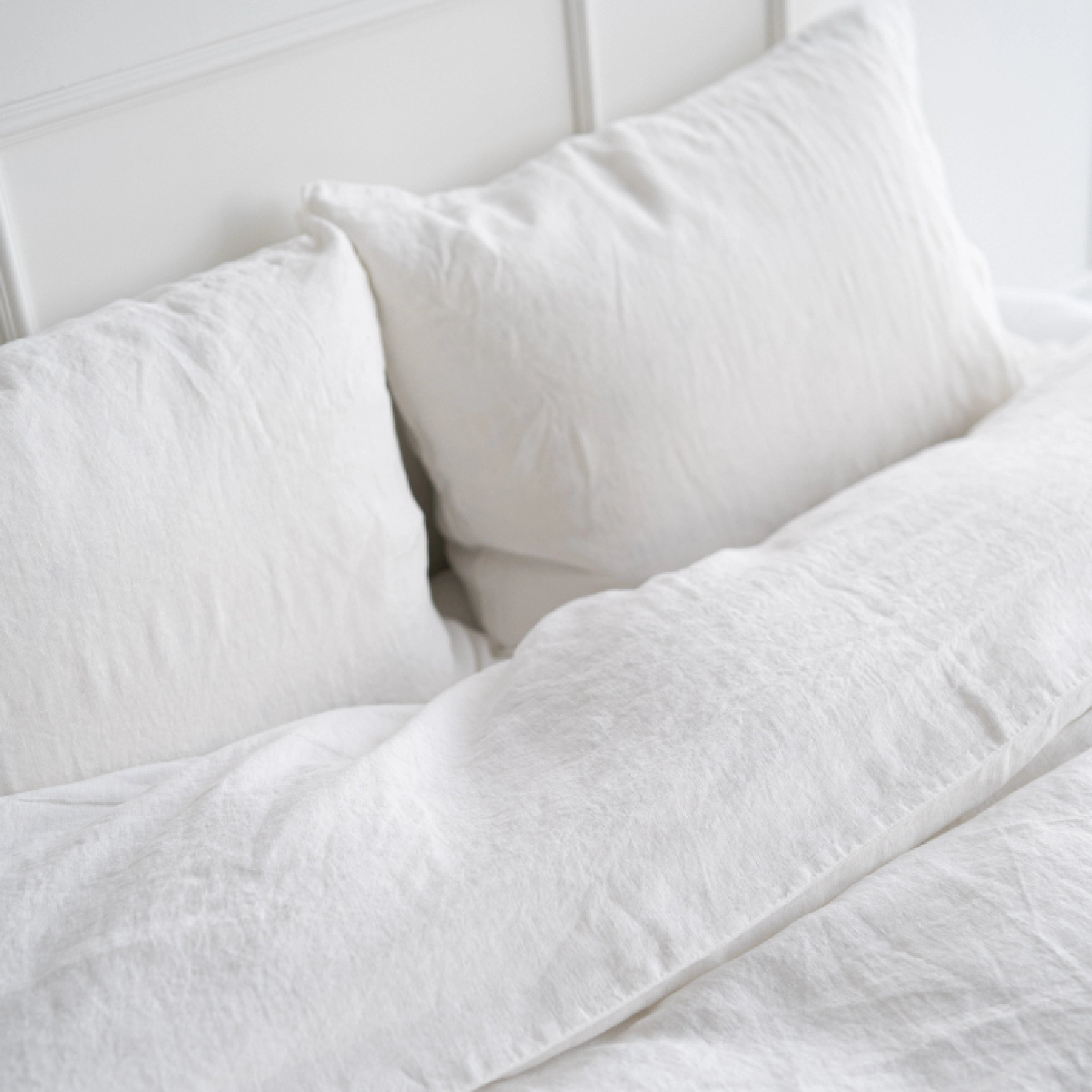 Soft white natural linen bedding including duvet cover and pillowcases.