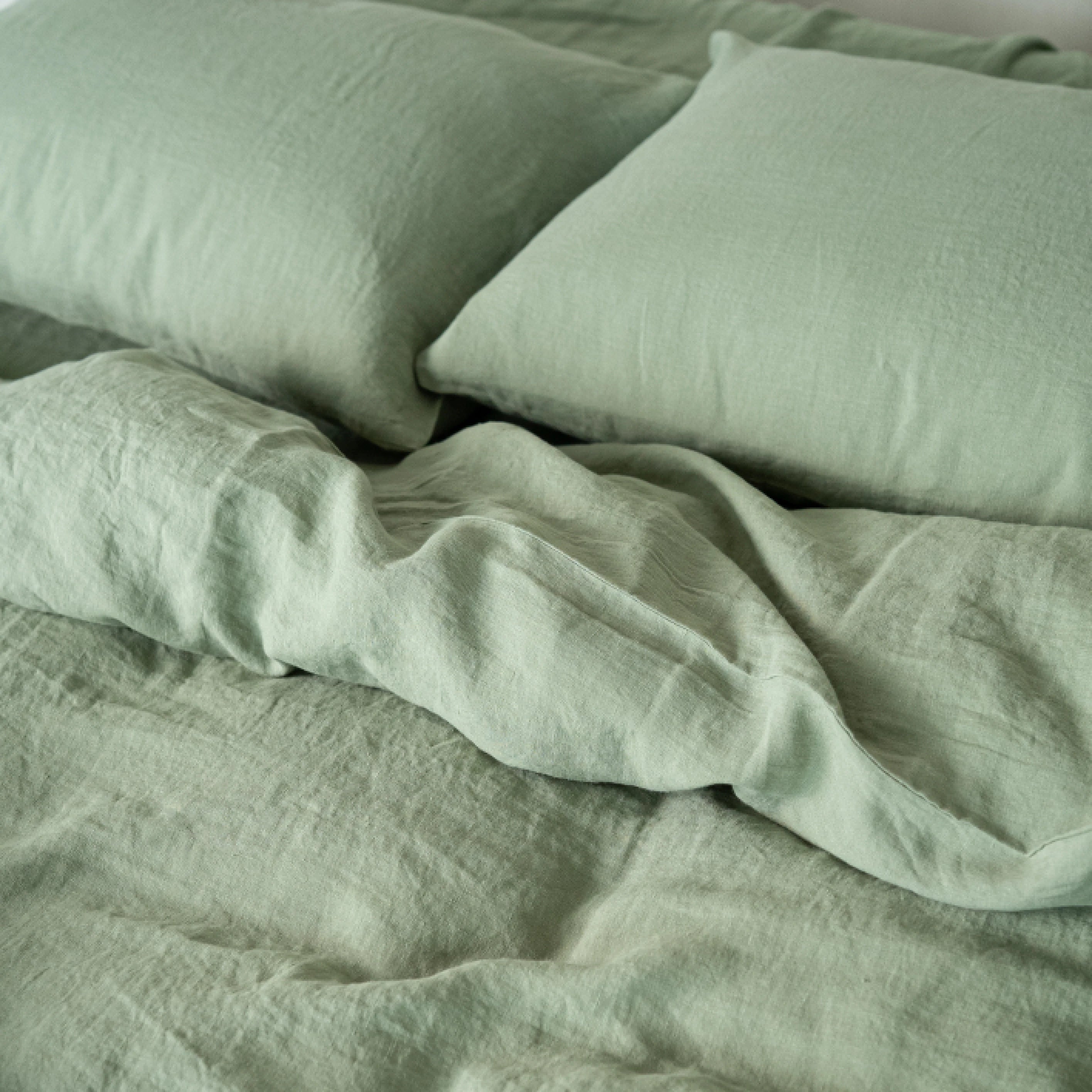 sage green bedding set with pillows on a bed, stonewashed