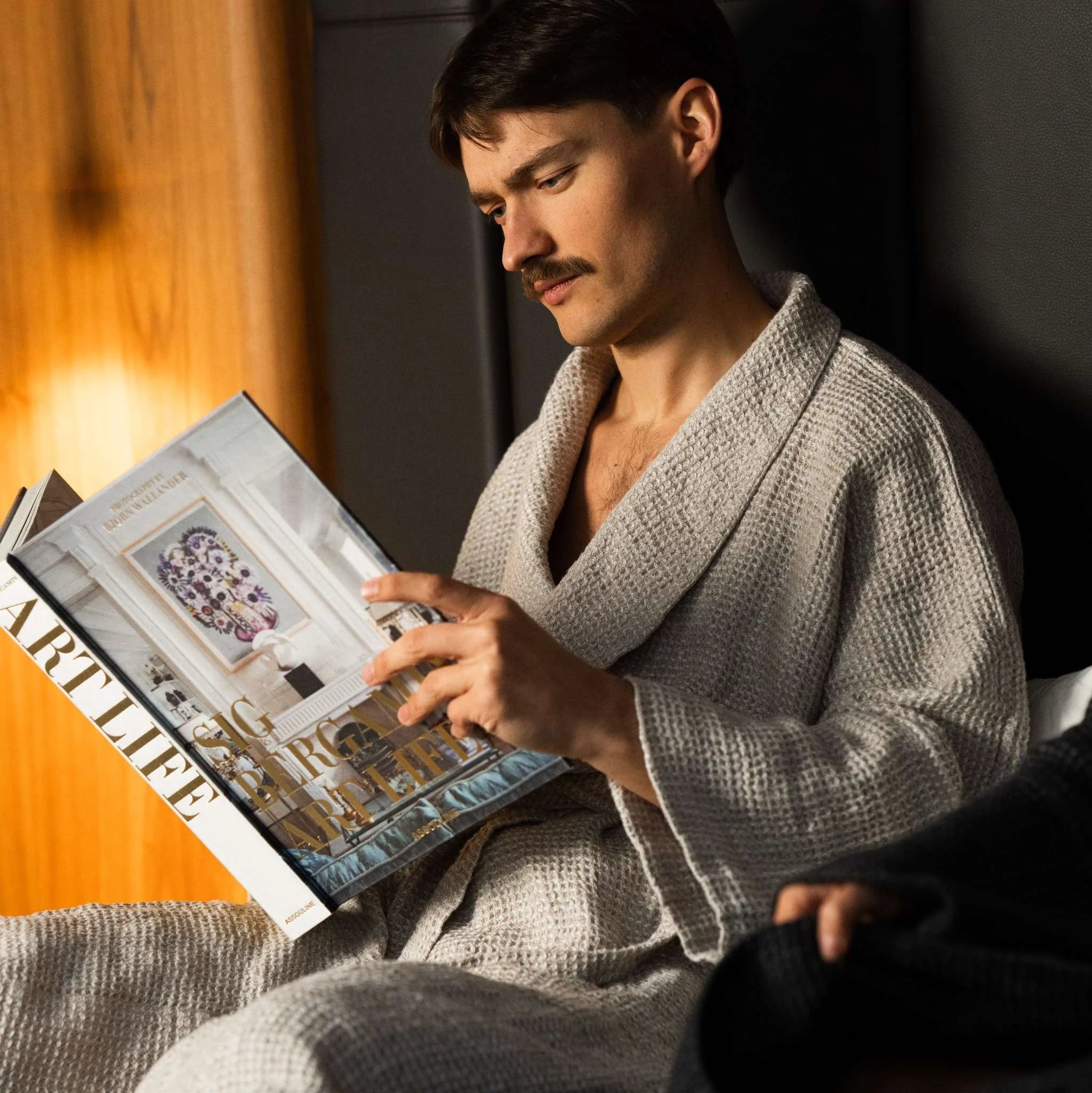 Beige linen robe styled on a bed with linen bedding, emphasizing natural tones, texture, and quiet luxury